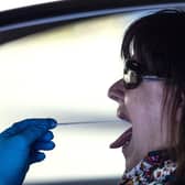A woman undergoes a PCR throat swab (AP Photo: Manu Fernandez)