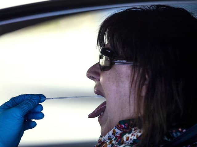 A woman undergoes a PCR throat swab (AP Photo: Manu Fernandez)