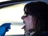 A woman undergoes a PCR throat swab (AP Photo: Manu Fernandez)