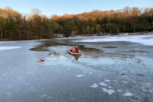 Firefighters hold Bobby safely in their arms after they rescued him from the middle of a frozen lake in Yarrow Valley Park, Chorley on Sunday, January 3. Pic: LFRS