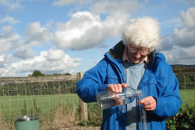 Muriel Lord pictured checking daily rainfall levels