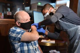 Pharmacist Zahir Patel vaccinates Les Jones at AFC FYlde's Mill Farm stadium in Wesham