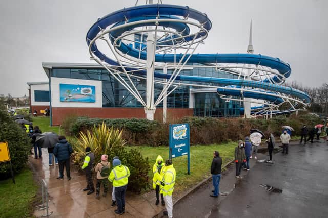 Members of the public queue outside a Covid-19 testing centre at Splash World in Southport