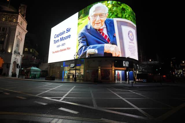 A tribute to Captain Sir Tom Moore, who has died at the age of 100 after testing positive for Covid-19, is broadcast on the Piccadilly Circus lights, in central London