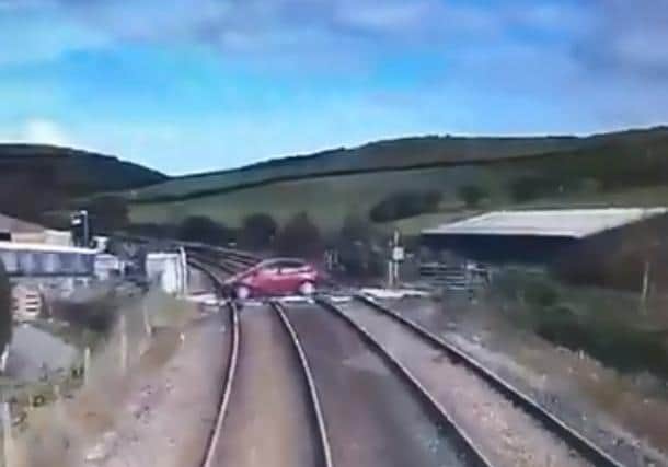 The red car was just seconds away from colliding with the train in the heart-stopping video. (Credit: @BTPLancs)