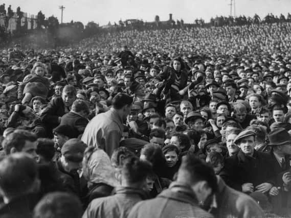 Women and children being passed over the heads of the crowd during the crush in which 33 football fans died during an FA Cup match between Stoke and Bolton Wanderers at Burnden Park, Bolton, on March 9, 1946