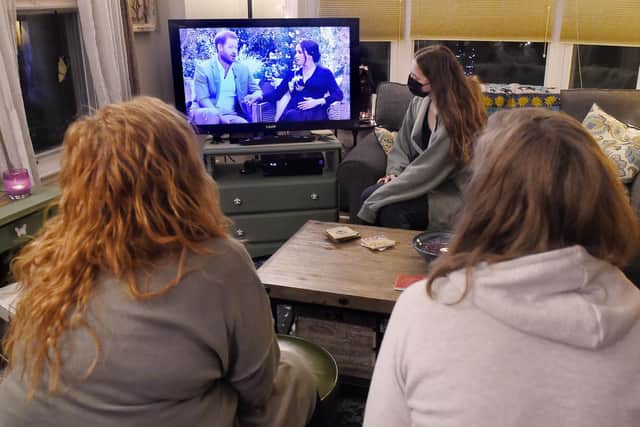 People watching a televised conversation between Prince Harry with his wife Meghan Markle and US host Oprah Winfrey