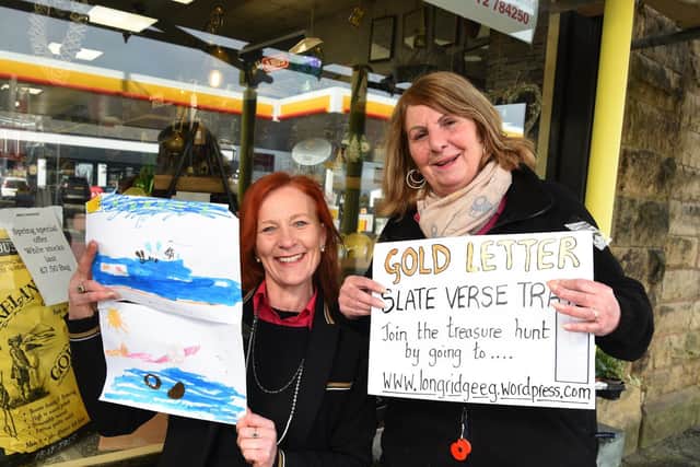 Swift's assistants Ann Richardson and Caroline Meades display a poster about the poetry trail  and a youngster's painting.