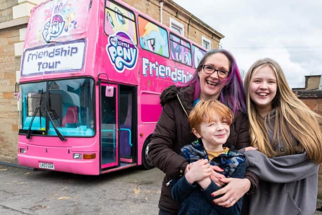Kerry Driver with her children Leah (12) and Tyler (six) and the big pink double decker bus.