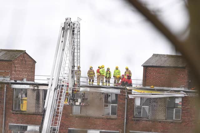 The windy weather has caused scaffolding along the roof of the four-storey building to come loose and fire crews are using a ladder platform to secure it