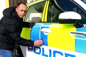 Kris Holt puts the finishing touches to one of his police cars. Picture by Tony North