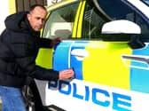 Kris Holt puts the finishing touches to one of his police cars. Picture by Tony North