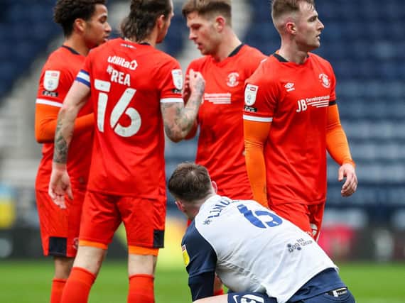 PNE defender Liam Lindsay down on his haunches as Luto's players celebrate their win
