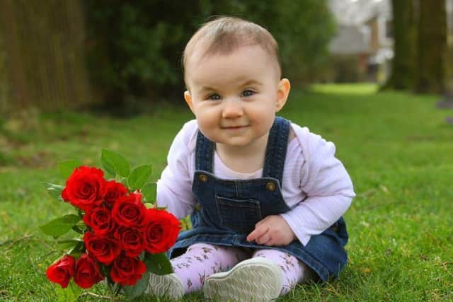 Baby Hayley holds a red rose to resemble Lancashire and remember those we have lost to the virus