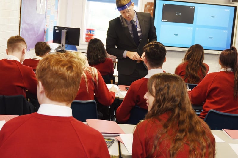 Staff and pupils go back to school after the Coronavirus pandemic closed schools in March 2020. The start of a new school year, September 2020, with social distancing and safety measures in place at Standish Community High School, Standish.  Maths teacher Mr Prout wears a protective face shield in class.