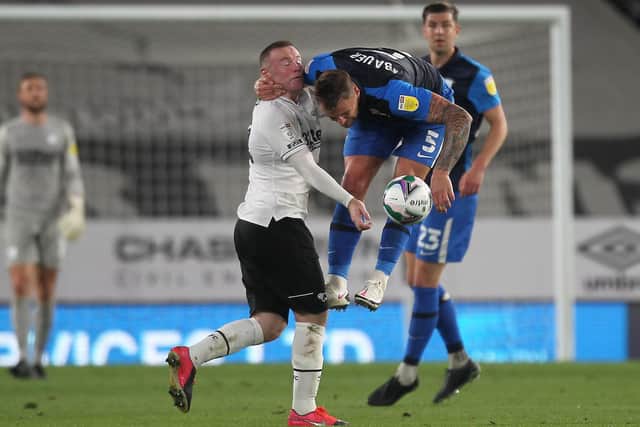 Preston North End defender Patrick Bauer challenges Derby's Wayne Rooney