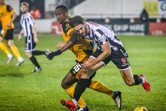 Chorley's Harry Cardwell fends off Wolves Willy Boly in the fourth round of the FA Cup (photo: Stefan Willoughby)