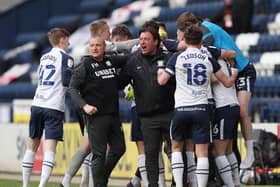 Brad Potts (hidden) is mobbed  by his team-mates and  interim head coach Frankie McAvoy after scoing his last-gasp equaliser