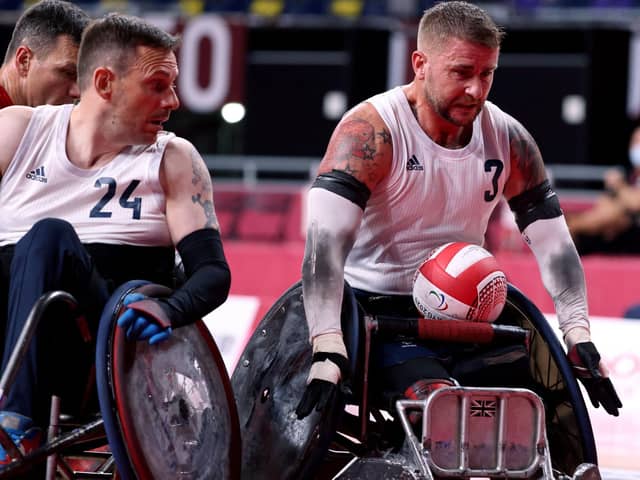 Britain's Stuart Robinson (R), a veteran who was wounded in Afghanistan, rolls to score during the pool phase group B wheelchair rugby match between Britain and Canada during the Tokyo 2020 Paralympic Games at the Yoyogi National Stadium in Tokyo on August 25, 2021. (Photo by Behrouz MEHRI / AFP) (Photo by BEHROUZ MEHRI/AFP via Getty Images)