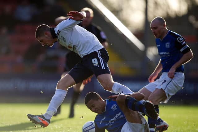 PNE striker Jamie Proctor hurdles a tackle against Rochdale at Spotland