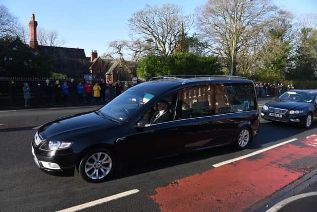 Prema Taylor's funeral cortege pauses outside the gates of the Harris Orphanage.