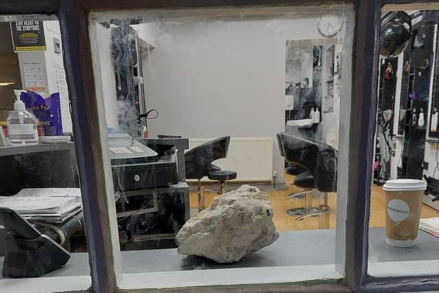 The repaired window with one of the rocks used to penetrate it.