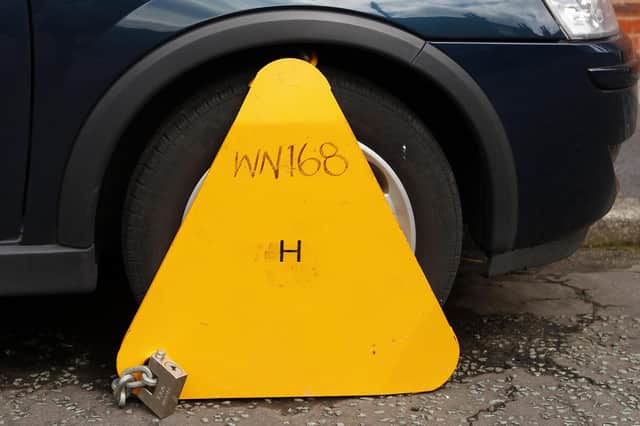 Motorists will receive greater protection from "aggressive debt collection and unreasonable fees" through a 50% cut to the private parking fine cap, the Government has said.