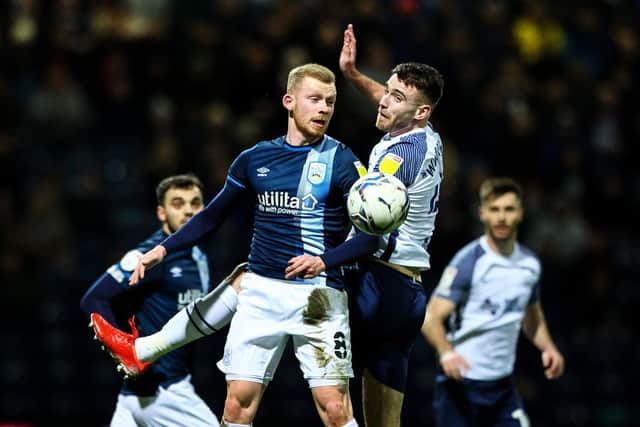 Preston midfielder Ben Whiteman challenges in the air with Huddersfield's Lewis O'Brien