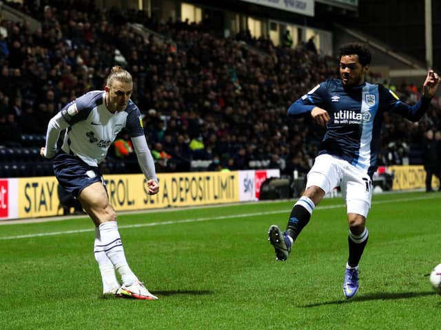 Brad Potts crosses under pressure from Huddersfield Town's Duane Holmes