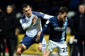 Preston North End’s Josh Earl challenges Huddersfield defender Ollie Turton