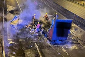 A lorry burst into flames after strong winds caused it to crash into a motorway bridge on the M6 between Preston and Wigan.