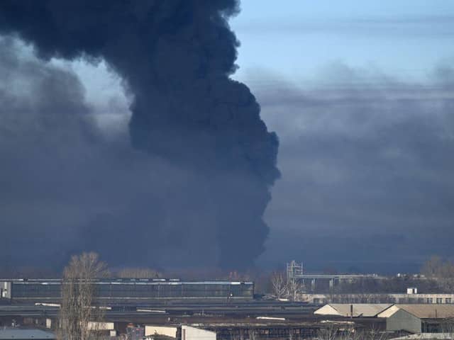 Black smoke rises from a military airport in Chuguyev near Kharkiv on February 24, 2022. - Russian President Vladimir Putin announced a military operation in Ukraine today with explosions heard soon after across the country and its foreign minister warning a "full-scale invasion" was underway.