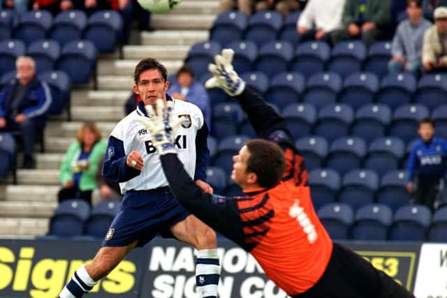 Preston North End striker Lee Ashcroft lifts a shot over Brentford goalkeeper Kevin Dearden at Deepdale in October 1997