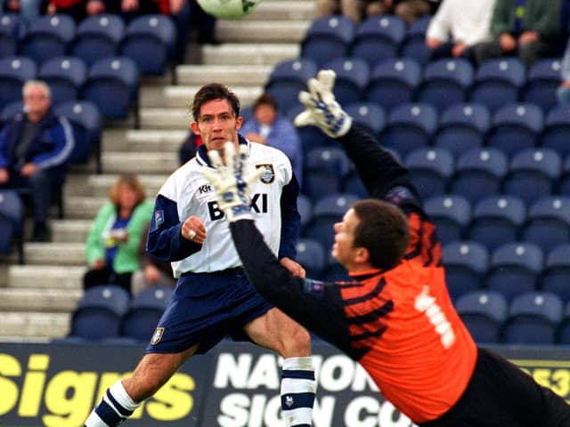 Preston North End striker Lee Ashcroft lifts a shot over Brentford goalkeeper Kevin Dearden at Deepdale in October 1997