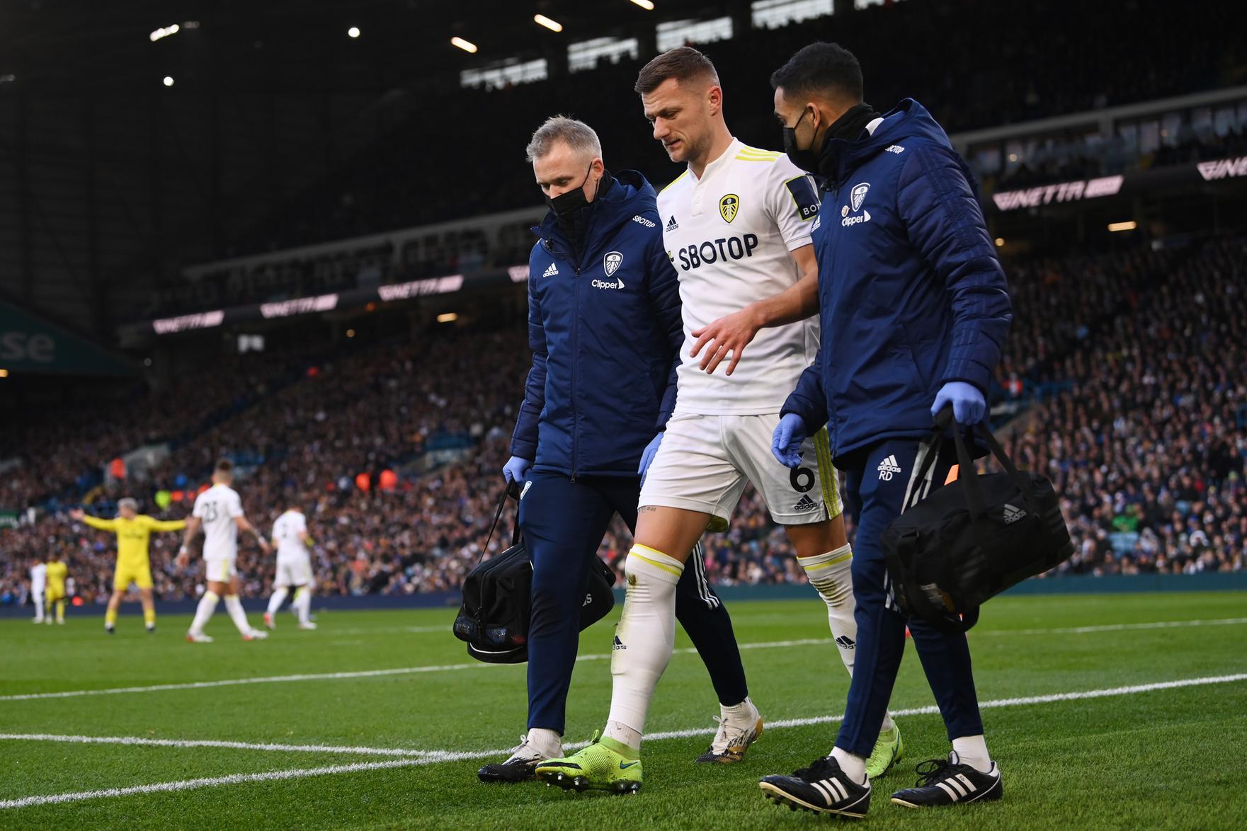 Leeds United captain Liam Cooper is helped off the field after injuring his hamstring during the Whites' 2-2 draw with Brentford in December. Pic: Stu Forster