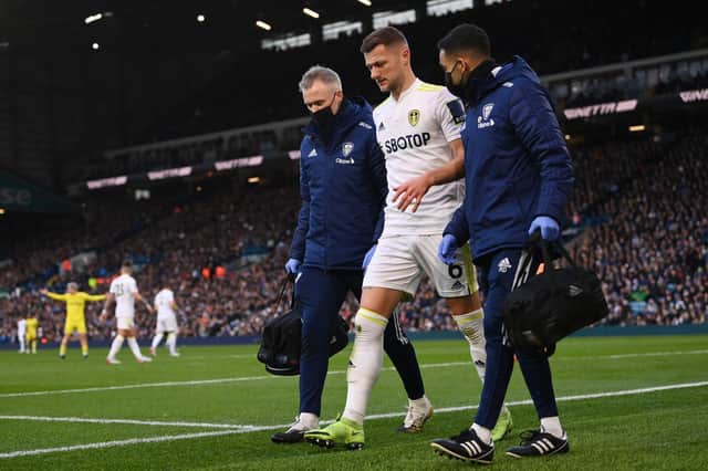 Leeds United captain Liam Cooper is helped off the field after injuring his hamstring during the Whites' 2-2 draw with Brentford in December. Pic: Stu Forster