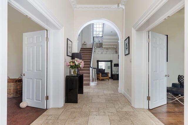 Doors lead off the main hallway, with an open arch through to the staircase and further accommodation.