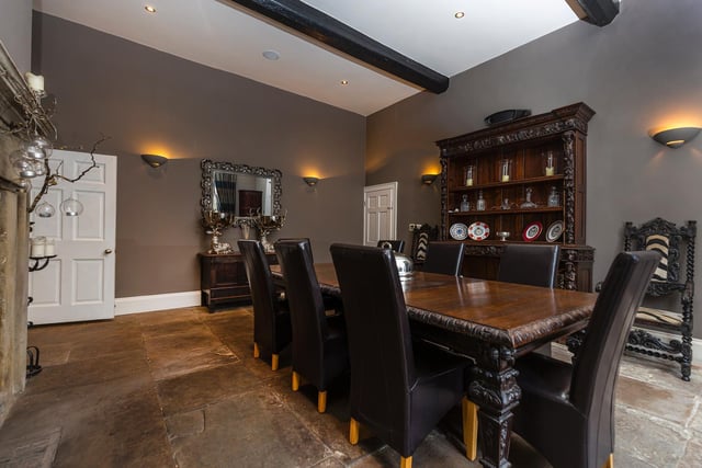 A beamed dining room with fireplace and Yorkshire stone flagged flooring.