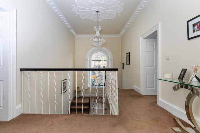 A stunning arched window lights the first floor's gallery landing.