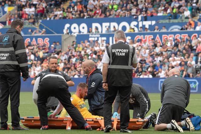 Louis Moult is treated on the pitch after damaging his knee against Swansea in August 2019