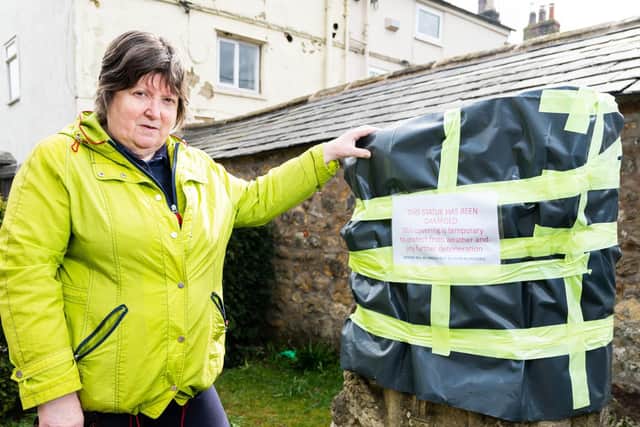 Coun Alison Brown pictured by the A Celebration of Community sculpture which has been damaged and is now covered to protect it, pending repairs.  
Photo: Kelvin Stuttard