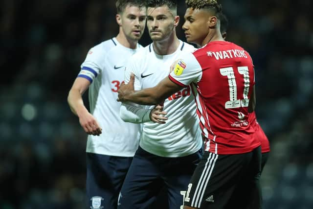 PNE defender Andrew Hughes gets to grips with Brentford striker Ollie Wtkins at Deepdale