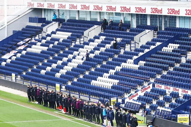 Coaching staff and substitutes of both sides line the touchline during the two minute's silence for Prince Phillp, the Duke of Edinburgh