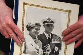 A person holds a photograph of Queen Elizabeth II and the Duke of Edinburgh outside Windsor Castle, Berkshire, following the announcement of his death at the age of 99. Picture date: Friday April 9, 2021. Picture: PA Wire/PA Images/Victoria Jones