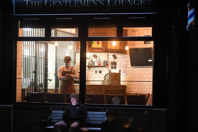 Waiting for midnight - first customer Cam Wilkinson pictured outside The Gentlemen's Lounge, Longridge  waiting for barber Ike Walmsley to open for business.  Photo: Neil Cross