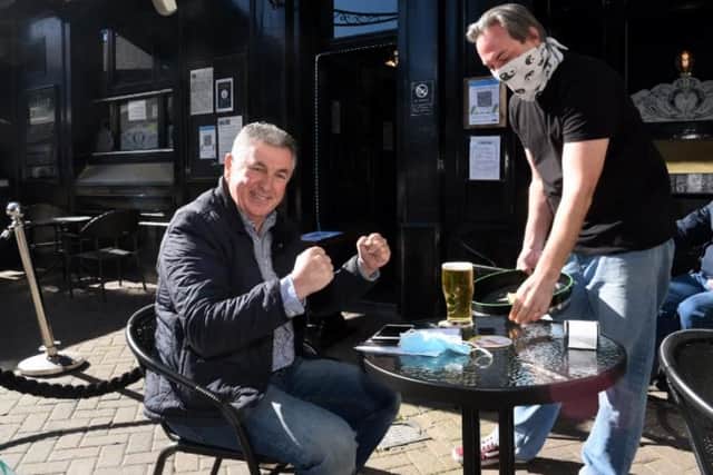 That special moment . . . intrepid reporter Ellis is served a 'proper' pint by landlord Gavin Corless.