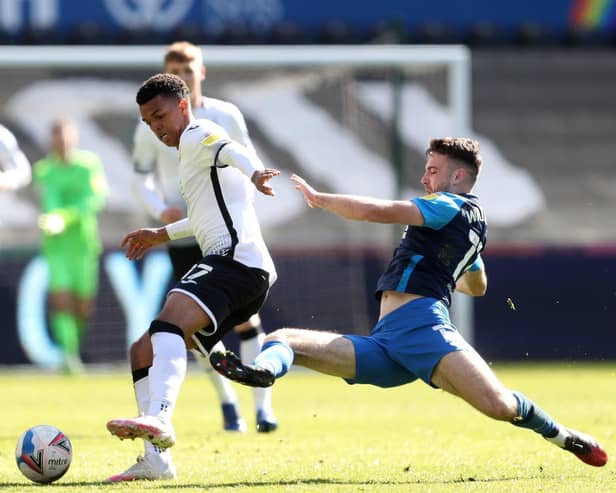 Preston North End midfielder Ben Whiteman makes a sliding challenge on Swansea's Morgan Whittaker at the Liberty Stadium