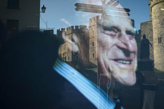 Windsor Castle is reflected in a shop window displaying a photograph of Prince Philip, Duke Of Edinburgh who died aged 99 on April 15, 2021 in Windsor
