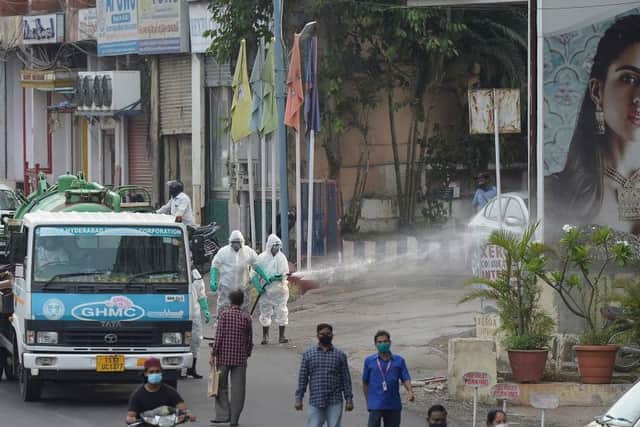 Members from the Disaster Response Force (DRF) of Telangana State, wearing protective gear spray disinfectant on a street against the spread of the Covid-19 coronavirus in Hyderabad on April 19