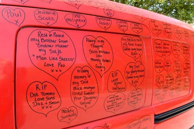 Messages remembering loved ones who have been lost during the pandemic are written on the van